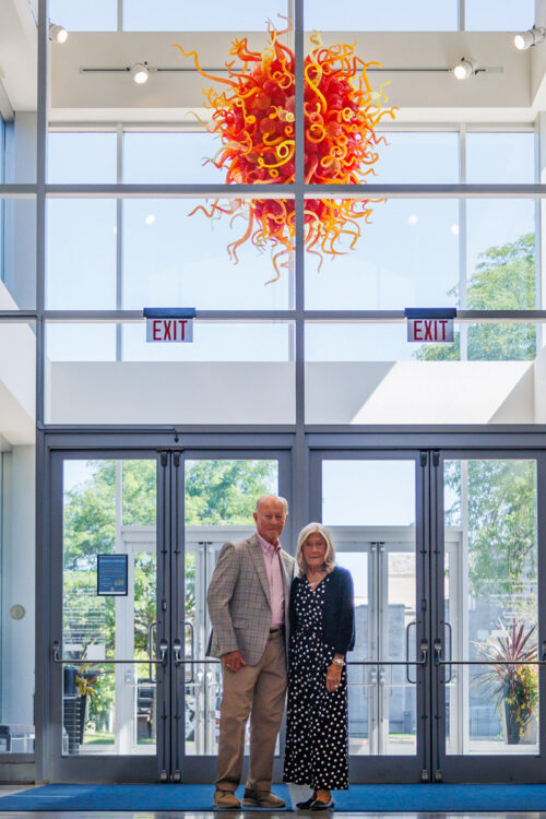 Adopt-Portrait-Langeland Norm & Bonnie Langeland with Kalamazoo Ruby Light Chandelier by Dale Chihuly